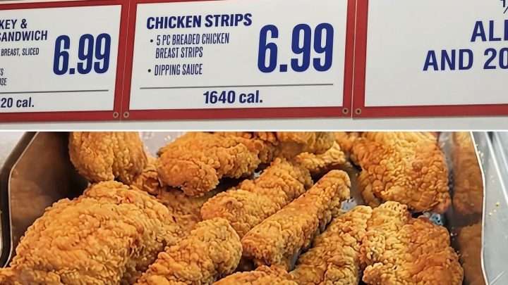 Pile of crispy fried chicken pieces in a metal tray beneath a red-framed menu board showing chicken strips for $6.99 and 1640 calories.